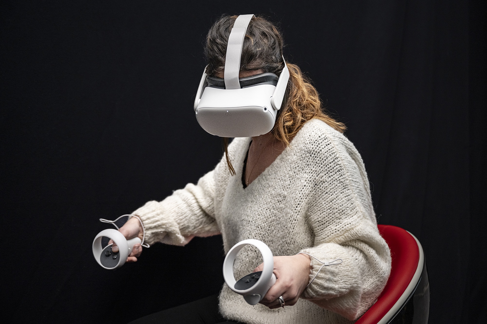 Femme avec un casque de réalité virtuelle blanc sur fond noir