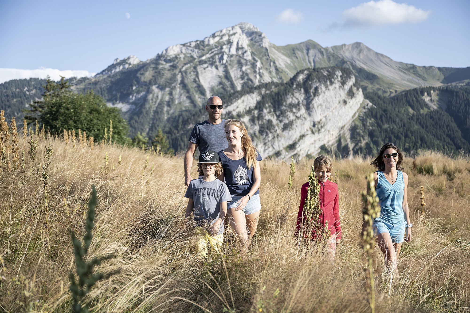 deux adultes et trois enfants se promenant en montagne