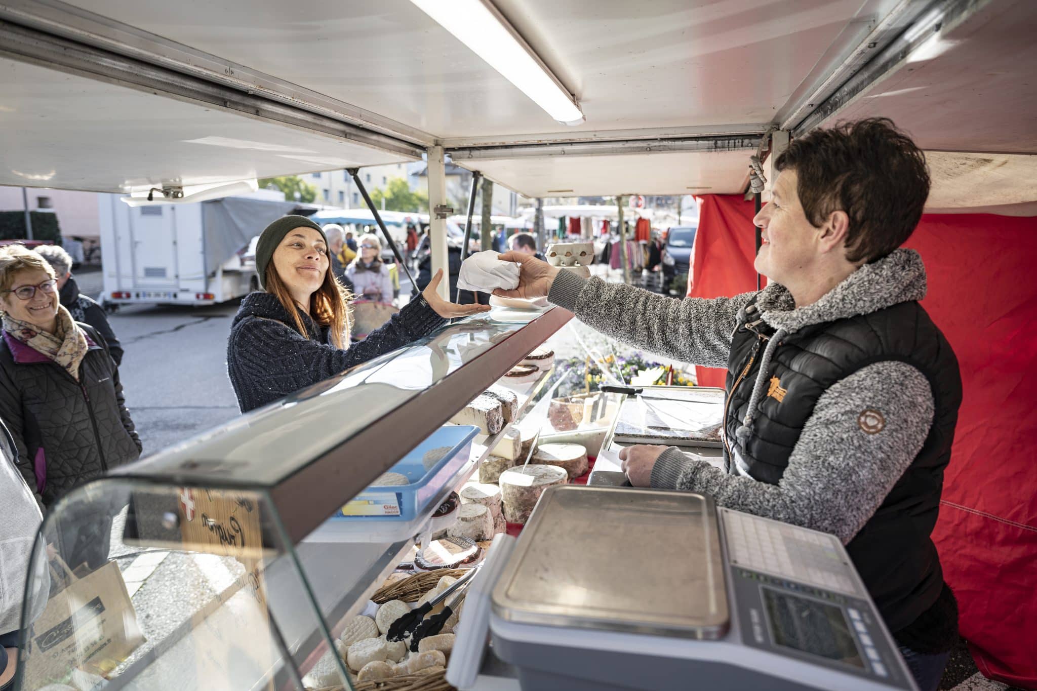 productrice fromage à son stand avec clients